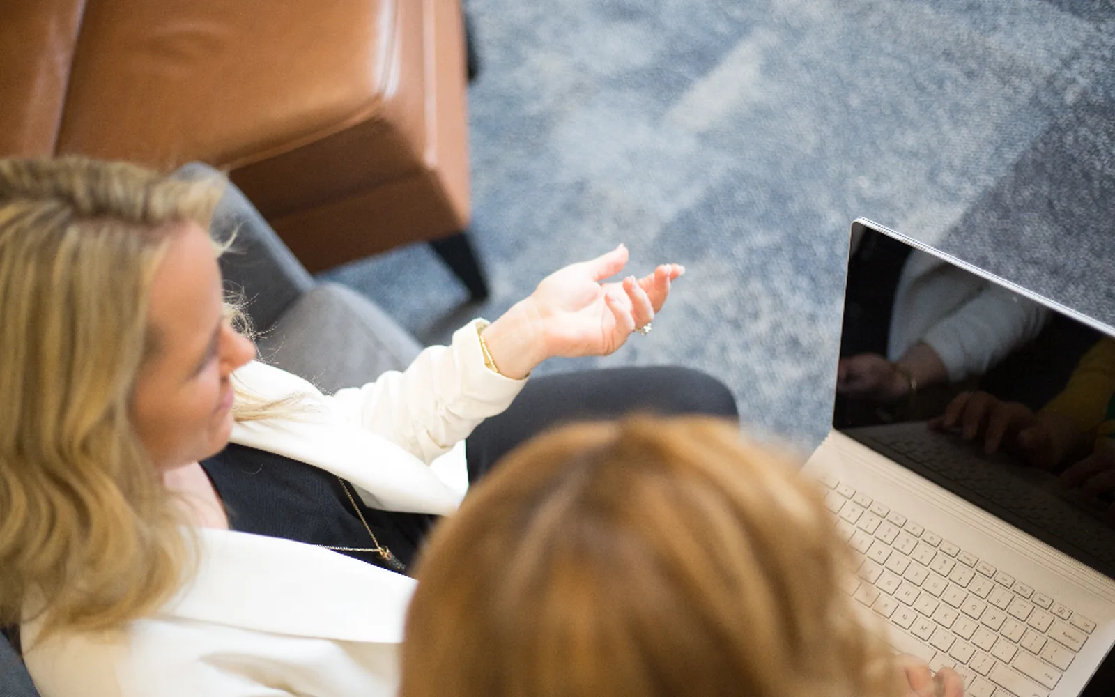 A consultant walking a client through a laptop screen