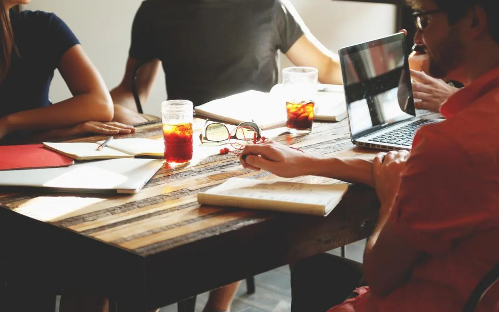 A team working together at a table with laptops and notebooks