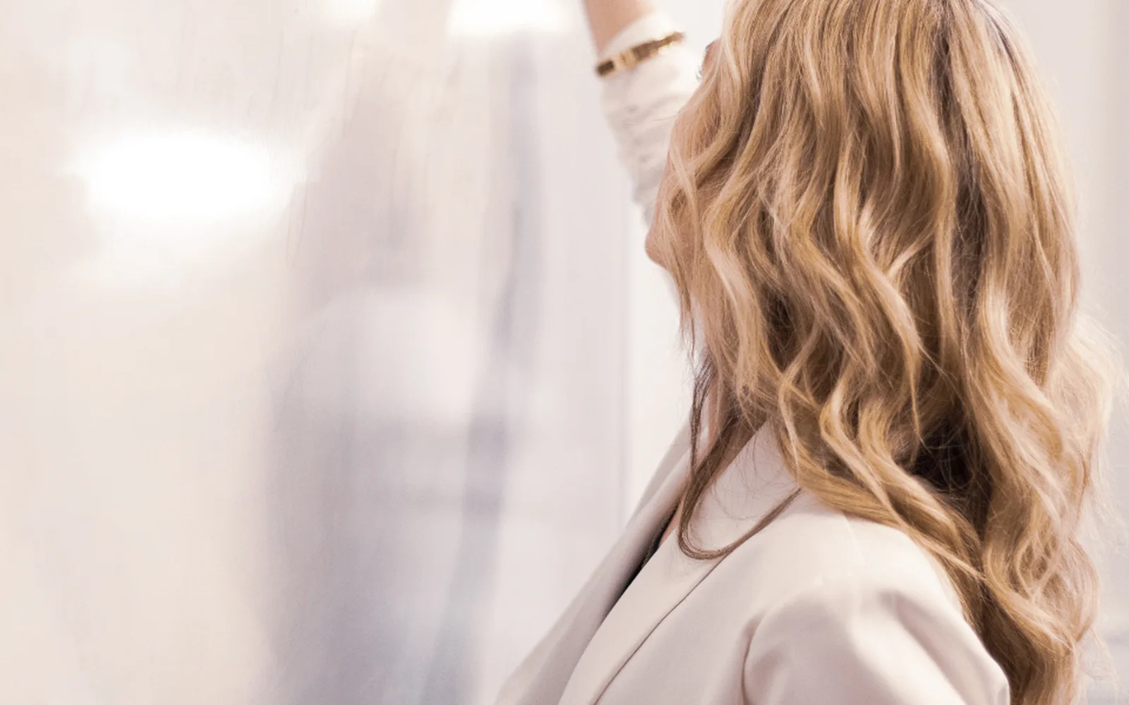 A woman writing sales goals on a whiteboard
